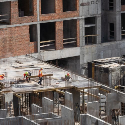Construction worker Concrete pouring during commercial concreting floors of building in construction